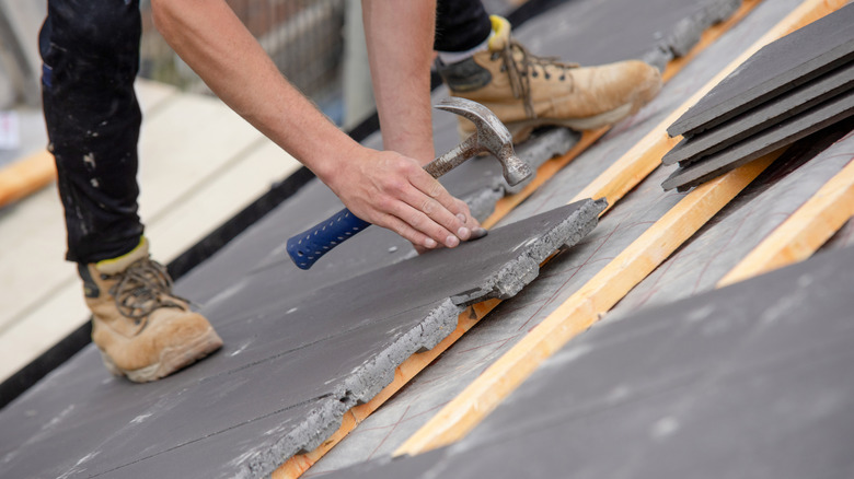 Roofer carefully installing a slate roof