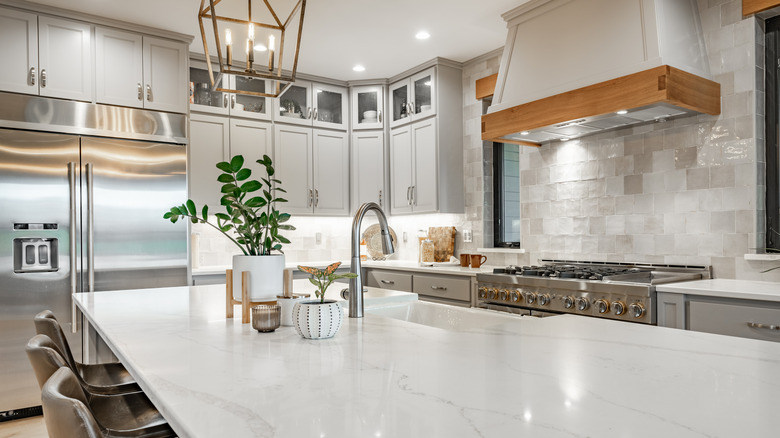 A well lit, clean kitchen space with marble countertops.