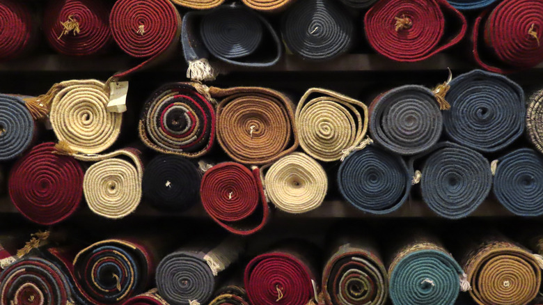 A wall of rolled up rugs
