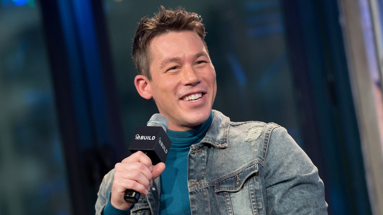 David Bromstad holding a mic and smiling.