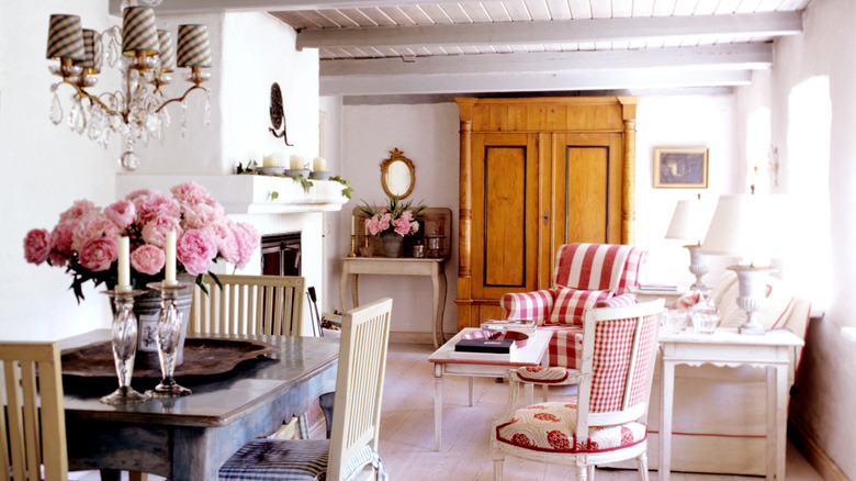 Cottage style interior with buffalo check chair, gingham lighting, old wardrobe, and modern lamps