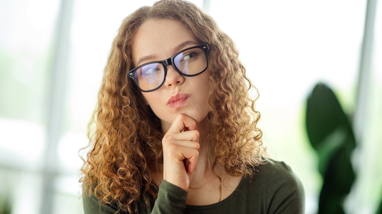 Thoughtful woman in glasses