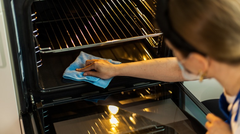 Person cleaning oven