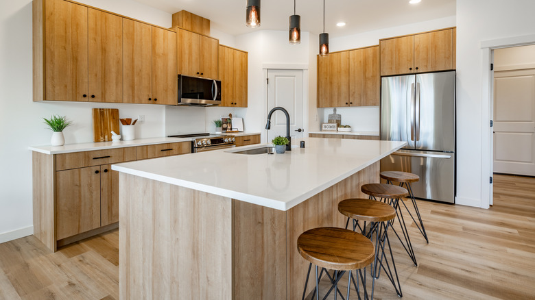 A modern kitchen island with wood cabinets.