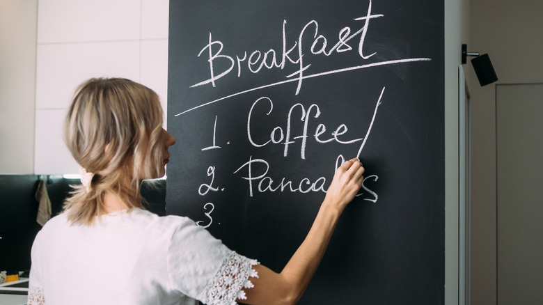 Woman writing on chalkboard wall