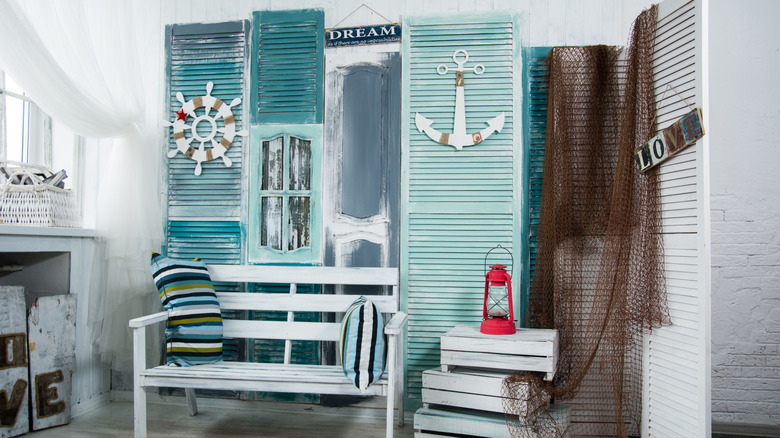 Nautical decoration with painted blue louvered closet doors and a whitewashed bench