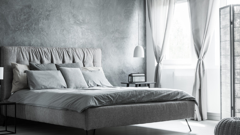 grey airy bedroom with gray curtains and textured wallpaper