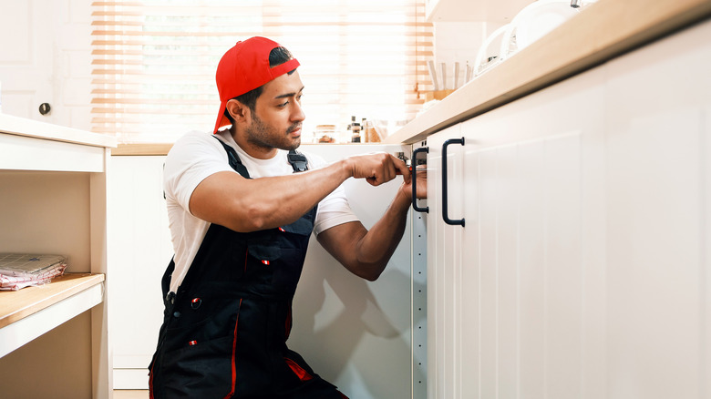 man installing cabinet handle