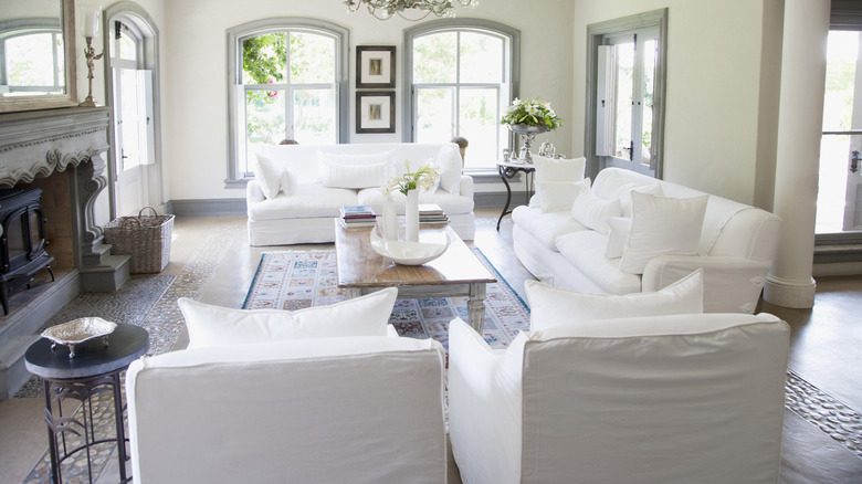 A living room seating area with white sofas and armchairs