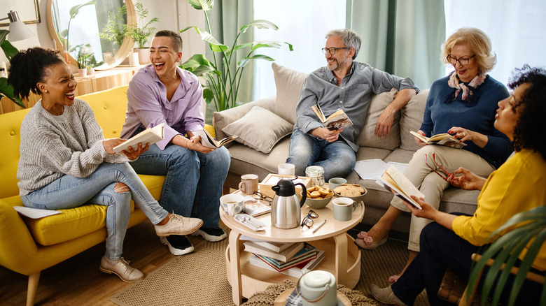 A group of people sitting in the living room talking and having coffee