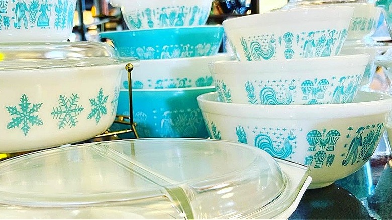 Collection of the Amish Butterprint Pyrex bowls in various sizes stacked on a table in a vintage shop