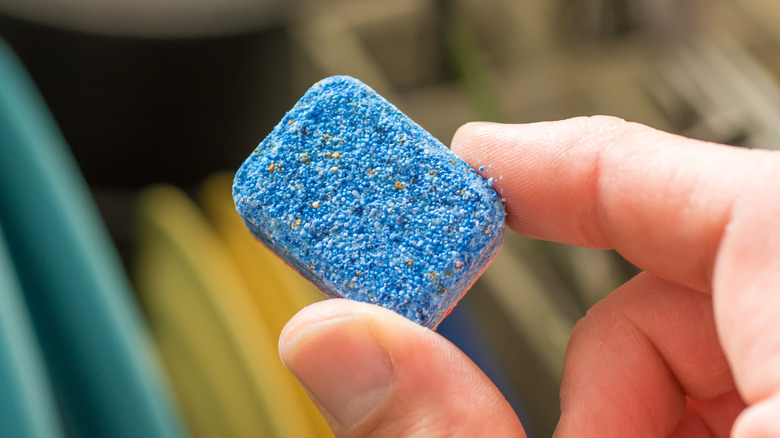 Hand holding dishwasher tablet