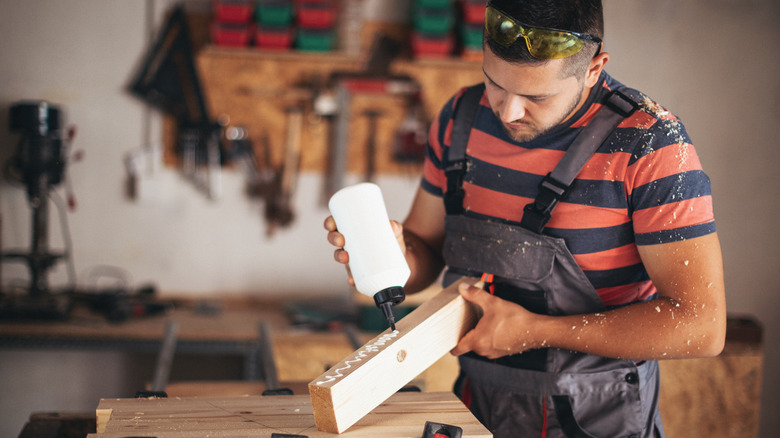 Man gluing wood plank