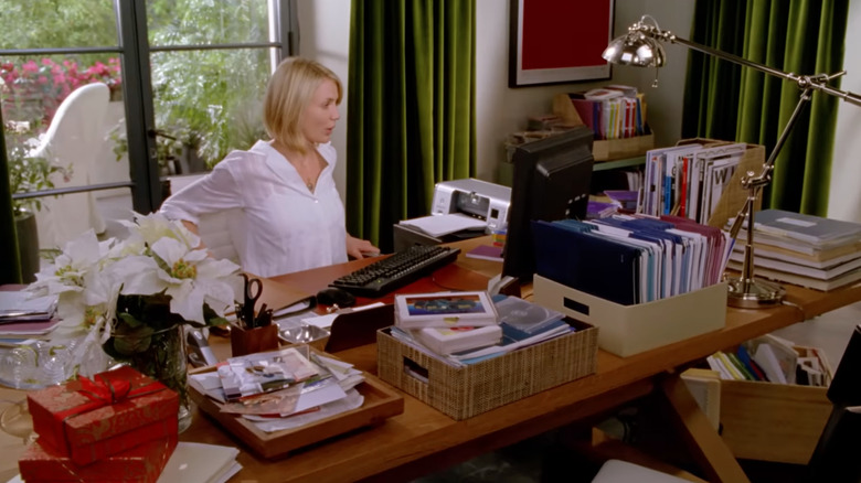 Cameron Diaz sits at a desk in the movie 