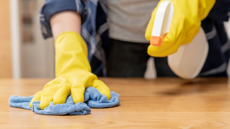 Person spraying and cleaning counter