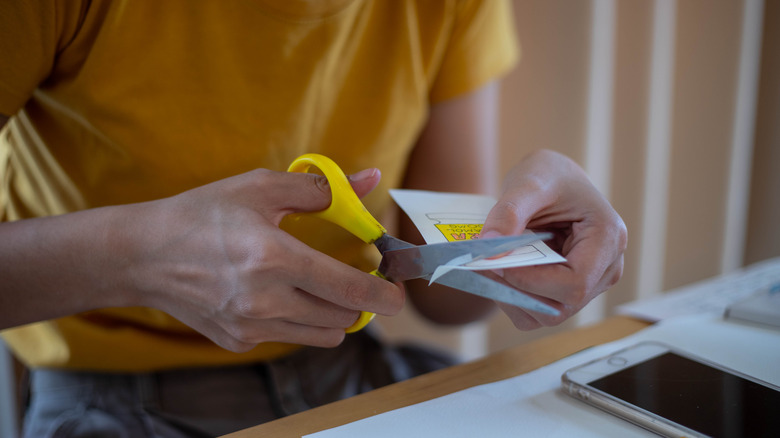 person cutting paper with scissors