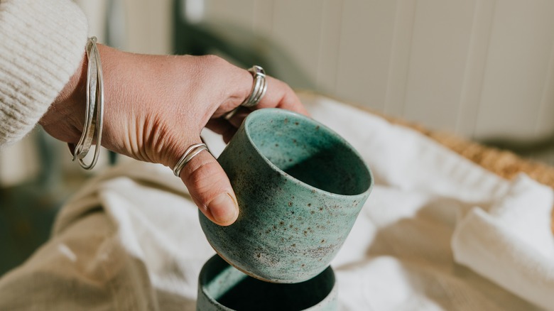 Person holding green ceramic mum