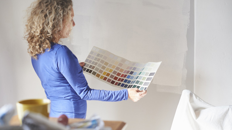 A woman comparing colors to wall
