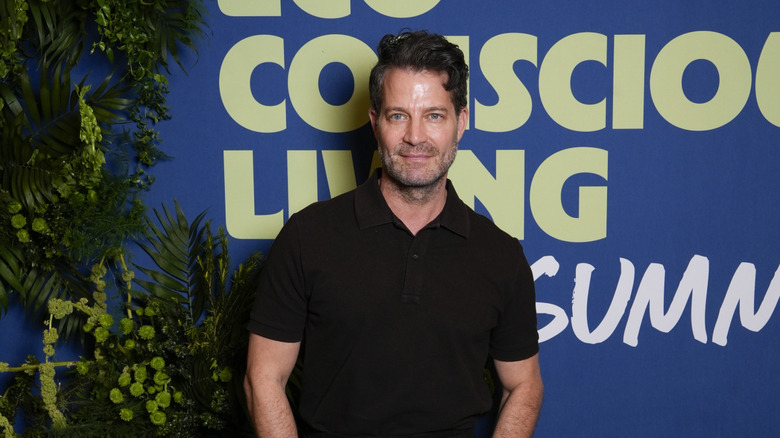 Nate Berkus standing in front of an advertising sign