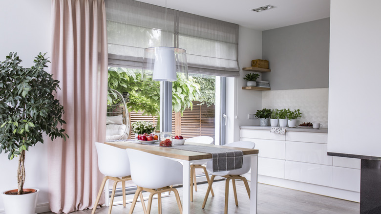 Roman blinds and drapes used together in a dining room