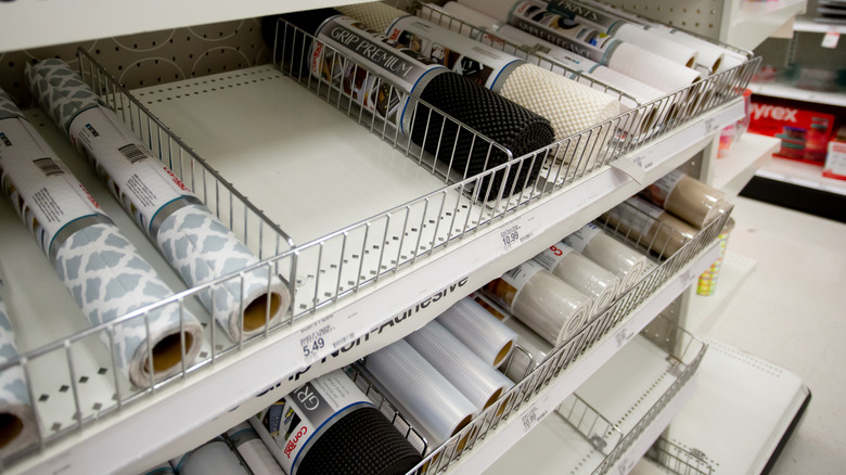 A store shelf filled with different kitchen cabinet shelf liners.