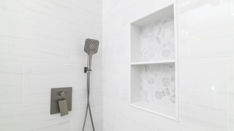 A practical shower niche with two shelves in a white-tiled shower