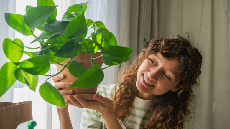 happy woman with thriving pothos