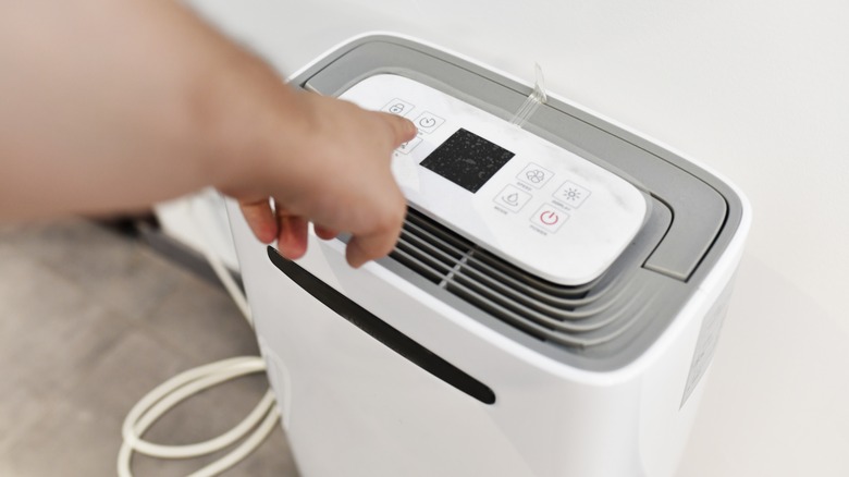 hand turning on a dehumidifier