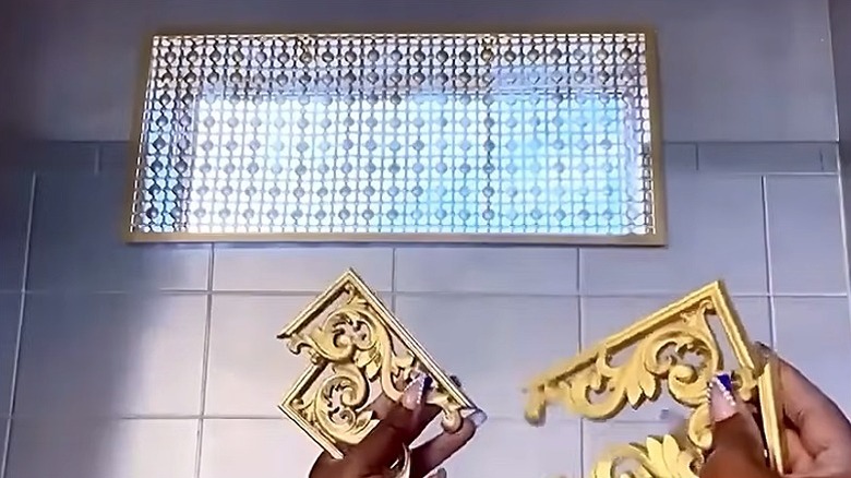 The completed window cover with the person's hands holding the corner decorations