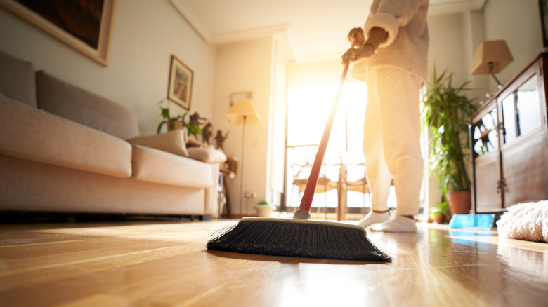 A person sweeping a hardwood floor.