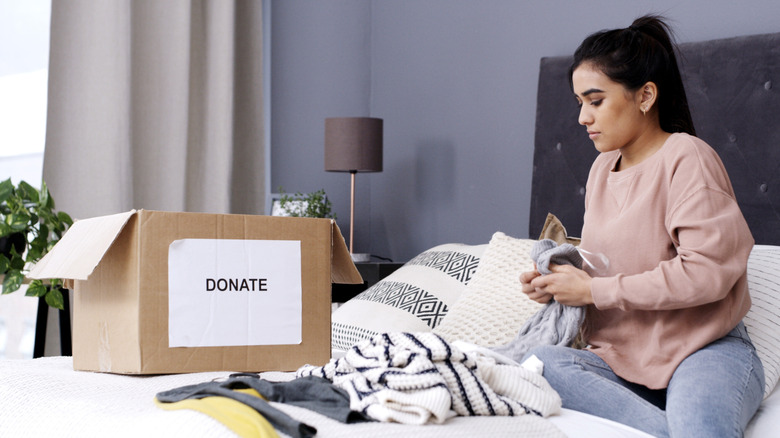 Woman decluttering her home using a box for donations