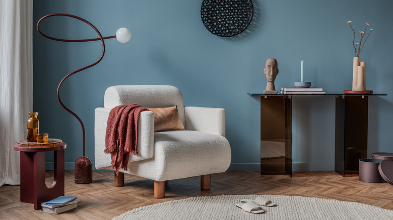 Room with white chair, twisted modern lamp, sculptural decor
