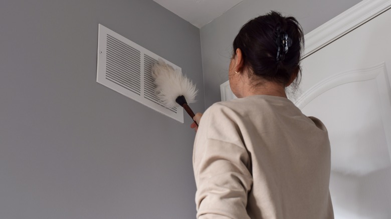 person dusting air vent