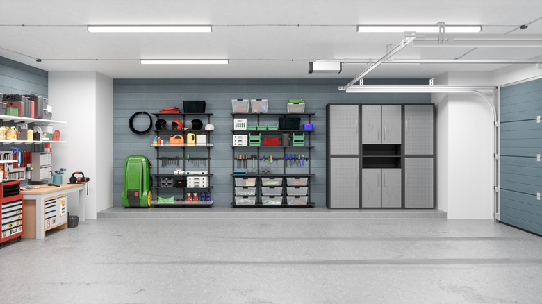 The tidy inside of a garage with storage neatly placed and bright lighting overhead.