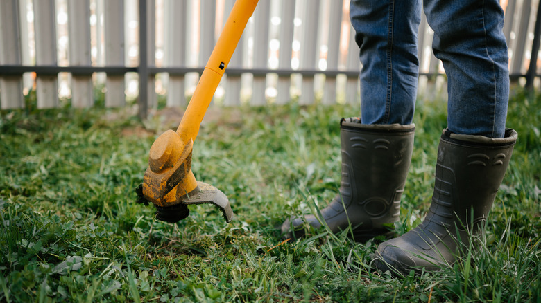 Wearing rubber gardening boots while weedwhacking