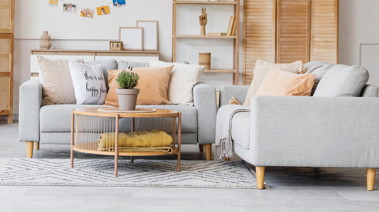 A coffee table placed in front of two chairs sitting at right angles to each other