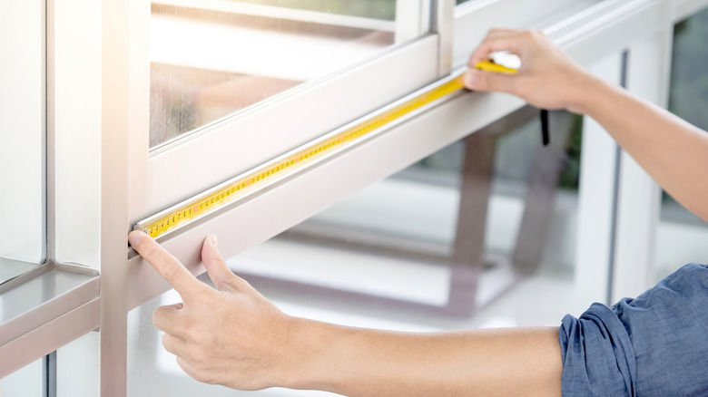 Person measuring a window