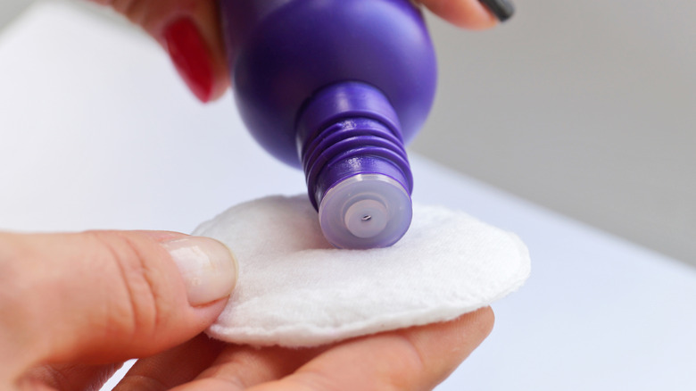 Person pouring nail polish remover