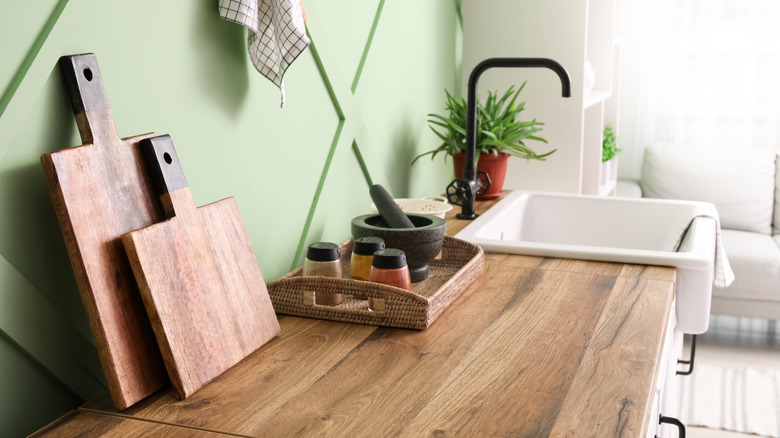 Kitchen countertop with wood cutting boards and basket tray