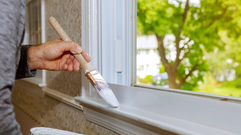 A man painting a window frame