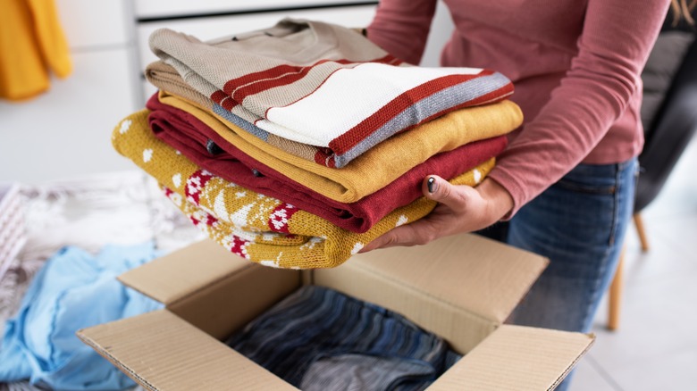 Woman packing folded clothing 