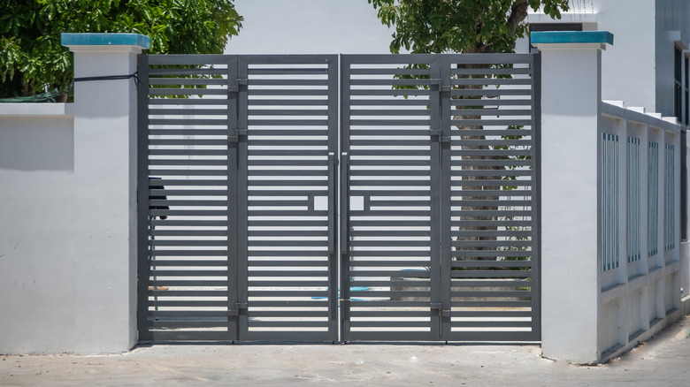 A fenced home with tall metal gates