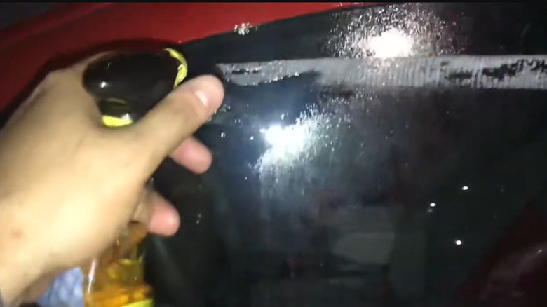 Someone spraying goo gone on sticker residue