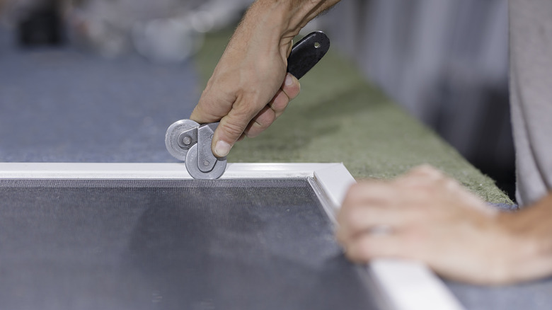 Person installing new window screen