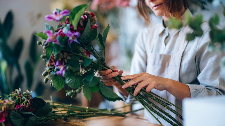 Woman arranging purple flowers