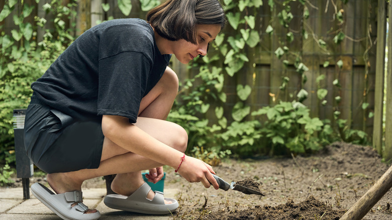 A young woman digging in the garden.