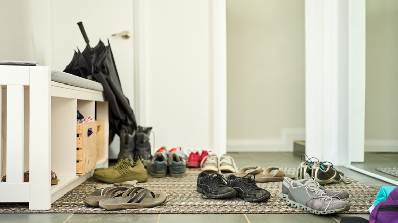 Shoes tossed by front door in a messy pile.