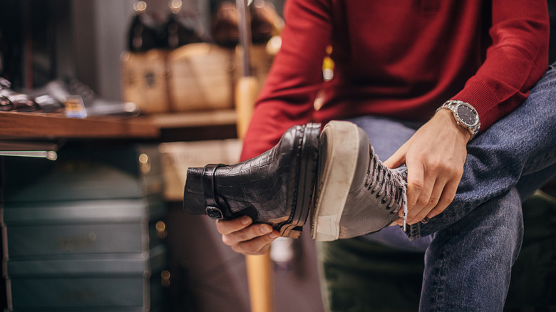 Man holding a shoe sole to sole with another shoe.
