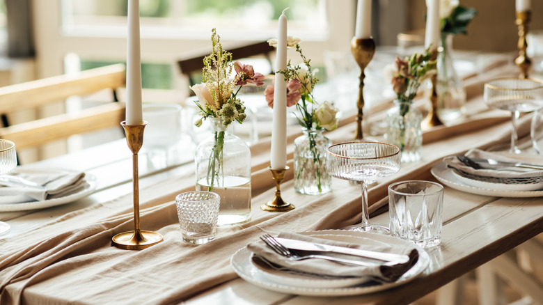 Beautifully set dinner table with candlesticks and glasses
