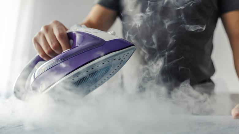 Person using hot steamer iron